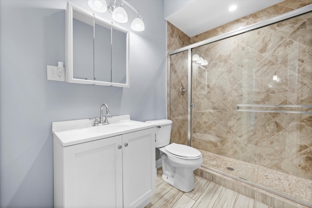 bathroom featuring vanity, toilet, and an enclosed shower