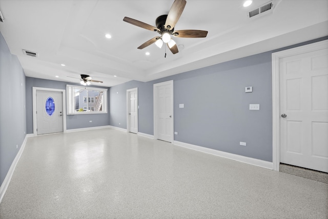 interior space with ceiling fan and a tray ceiling