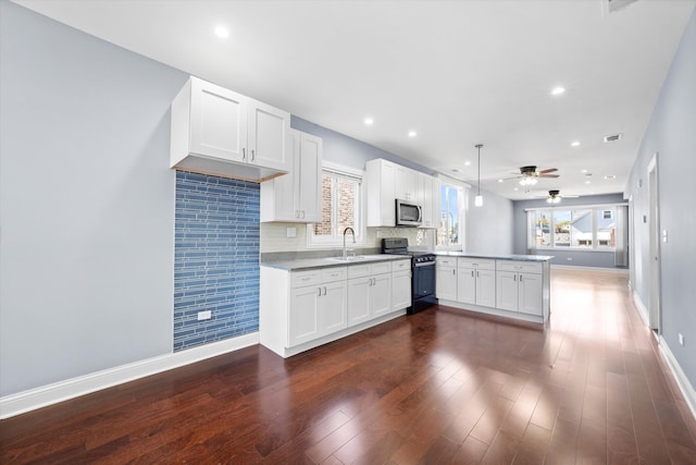 kitchen featuring kitchen peninsula, white cabinets, dark hardwood / wood-style floors, and black range