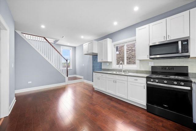 kitchen featuring white cabinets, sink, dark hardwood / wood-style flooring, and black stove