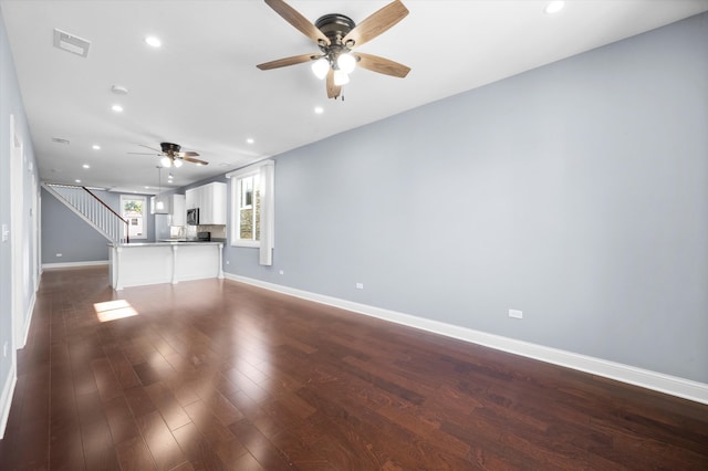 unfurnished living room with dark hardwood / wood-style floors and ceiling fan