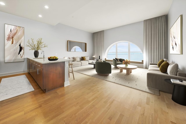 interior space with a water view, sink, and light hardwood / wood-style floors