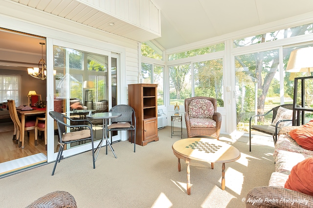 sunroom featuring vaulted ceiling, a chandelier, and a wealth of natural light