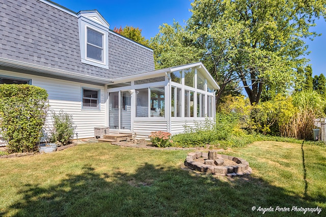 rear view of house with a yard and a sunroom