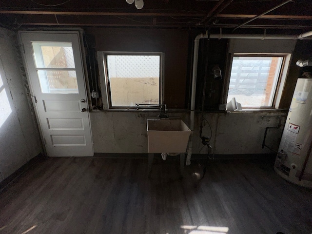 foyer entrance featuring water heater, sink, and dark hardwood / wood-style flooring