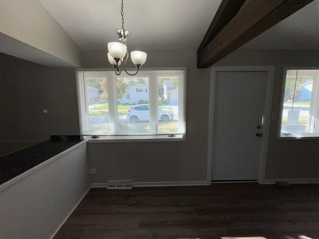 unfurnished dining area featuring a notable chandelier, plenty of natural light, and dark wood-type flooring