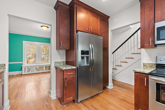 kitchen with light stone counters, stainless steel appliances, and light hardwood / wood-style floors