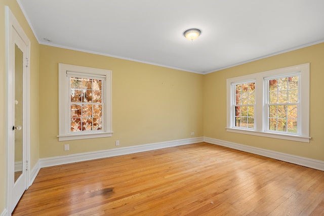 unfurnished room featuring crown molding, a wealth of natural light, and light hardwood / wood-style flooring