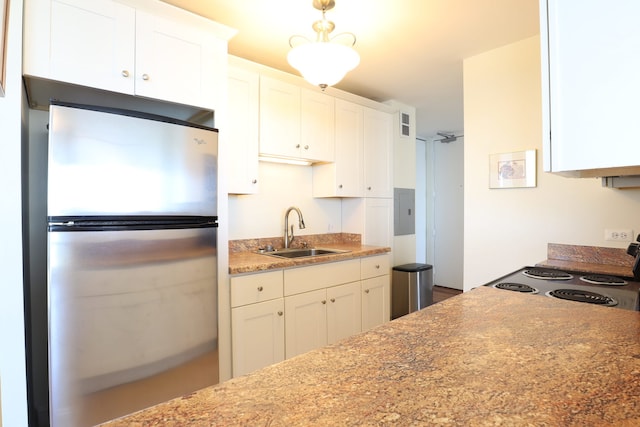 kitchen featuring sink, white cabinets, and stainless steel refrigerator