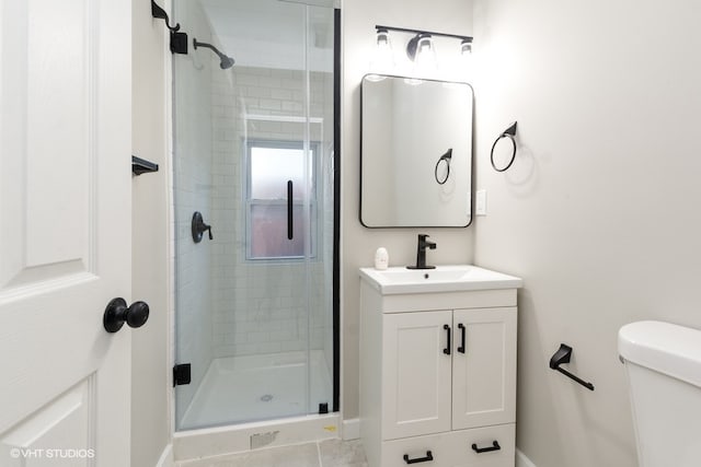 bathroom with tile patterned flooring, a shower with door, vanity, and toilet