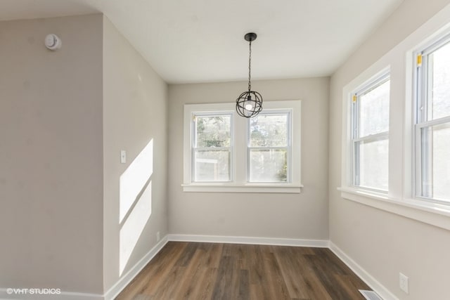 unfurnished dining area featuring dark wood-type flooring