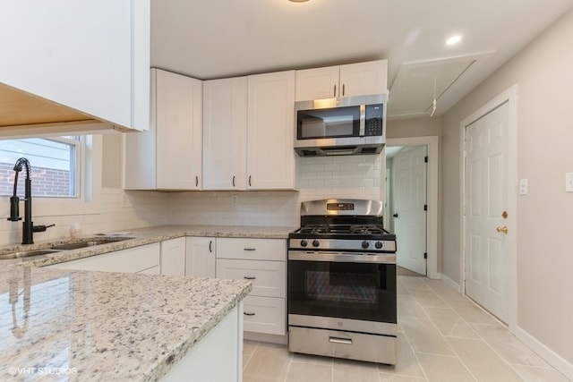 kitchen featuring white cabinetry, sink, stainless steel appliances, and tasteful backsplash