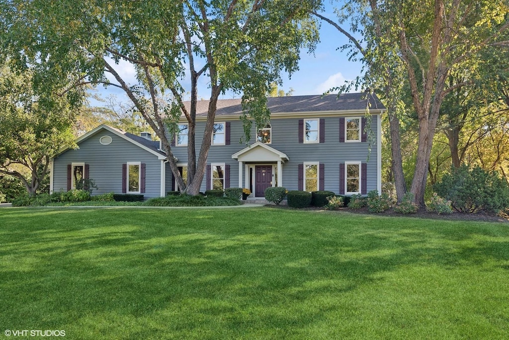 colonial-style house featuring a front lawn