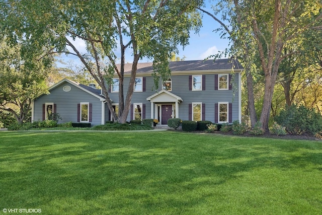 colonial-style house featuring a front lawn