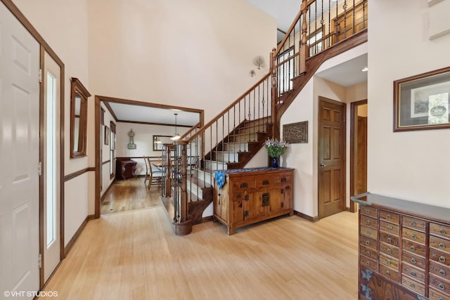 entryway featuring a towering ceiling and light hardwood / wood-style floors