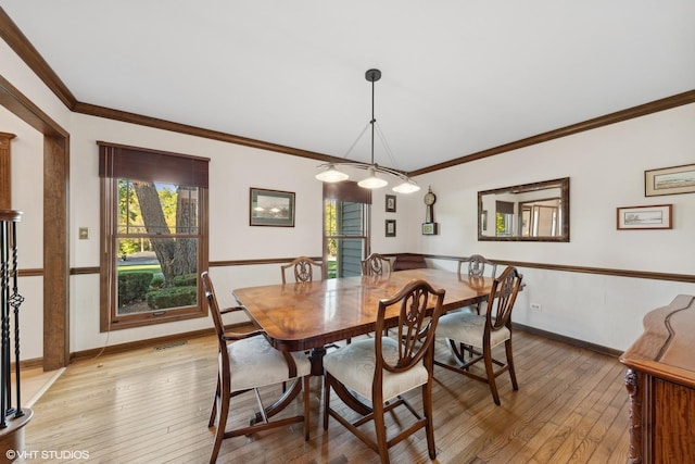 dining area with light wood-type flooring and crown molding