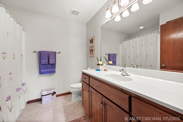 bathroom with toilet, vanity, and tile patterned floors