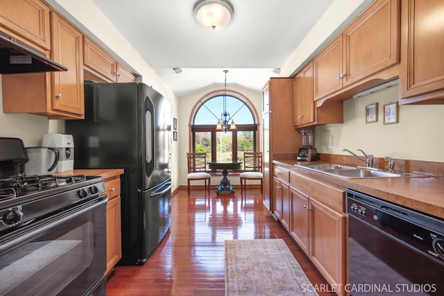 kitchen featuring vaulted ceiling, exhaust hood, sink, black appliances, and an inviting chandelier