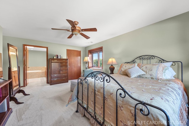 bedroom featuring connected bathroom, ceiling fan, and light carpet