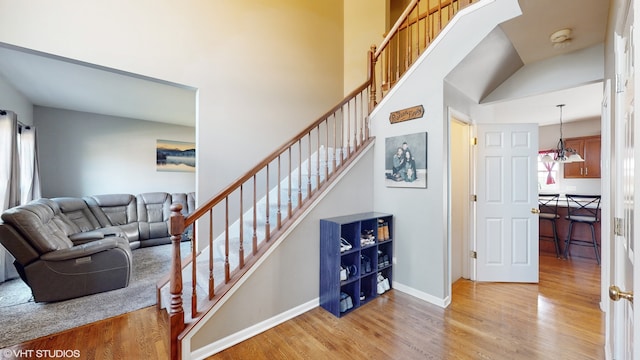 stairs featuring hardwood / wood-style floors and a notable chandelier