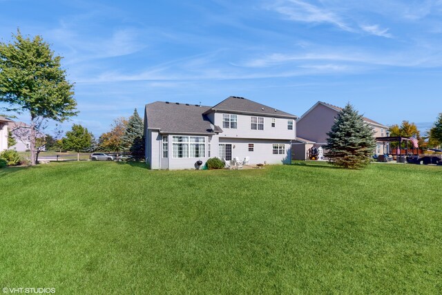 rear view of property featuring a lawn