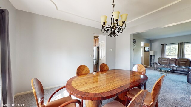 dining space featuring carpet and a chandelier