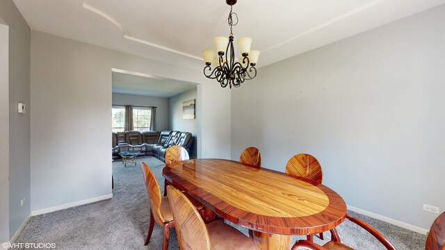 dining area with carpet floors and an inviting chandelier