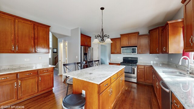 kitchen featuring pendant lighting, a breakfast bar, sink, appliances with stainless steel finishes, and a kitchen island