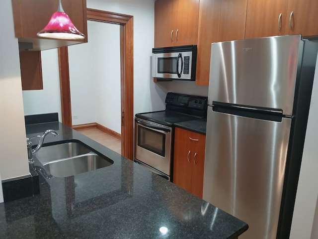 512 W Barry Ave Unit 201, Chicago, IL 60657 - kitchen with appliances with stainless steel finishes, a sink, brown cabinetry, and dark stone countertops