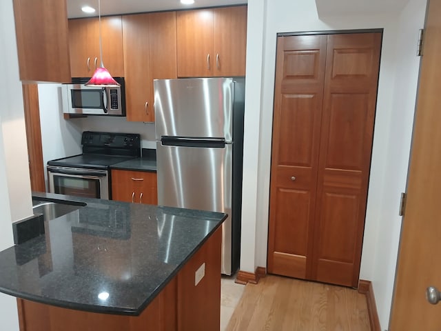 512 W Barry Ave Unit 201, Chicago, IL 60657 - kitchen with appliances with stainless steel finishes, brown cabinetry, light wood-type flooring, and dark stone counters