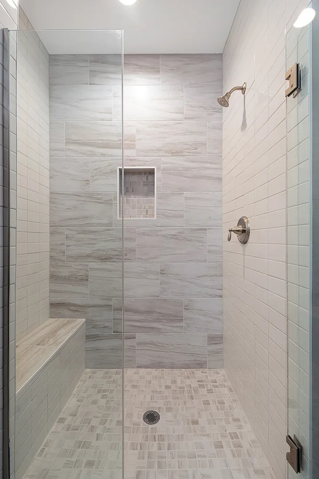 bathroom featuring a shower with door