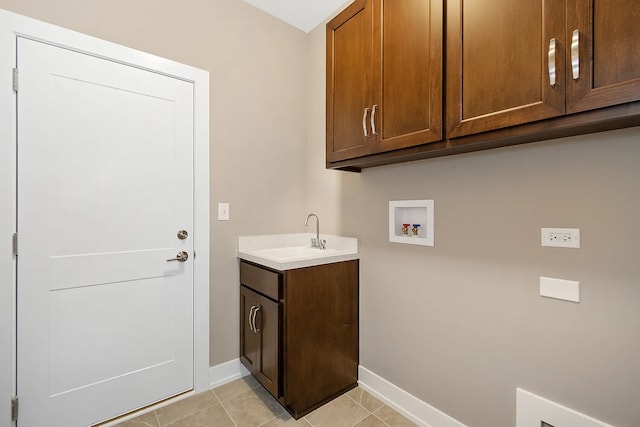 clothes washing area featuring washer hookup, sink, light tile patterned floors, and cabinets