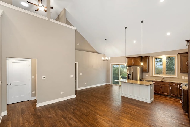 kitchen with a kitchen island, sink, hanging light fixtures, high vaulted ceiling, and stainless steel refrigerator with ice dispenser