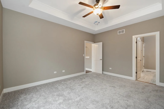 unfurnished bedroom featuring ceiling fan, a raised ceiling, connected bathroom, and carpet