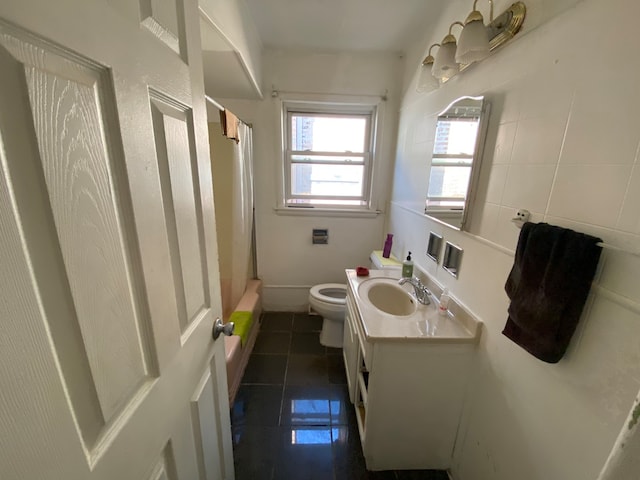 full bathroom with vanity, shower / bath combination with curtain, tile walls, tile patterned floors, and toilet