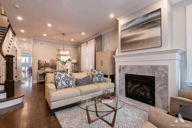 living room featuring a premium fireplace, crown molding, and hardwood / wood-style floors