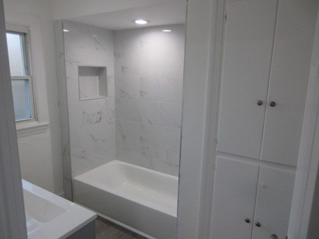 bathroom featuring vanity and tiled shower / bath