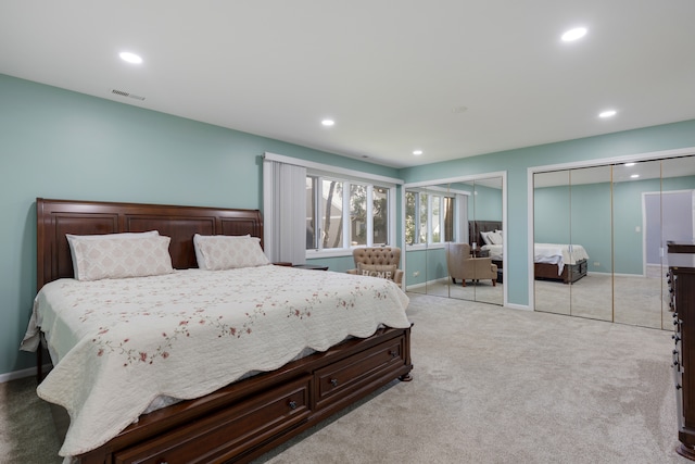 carpeted bedroom featuring multiple closets