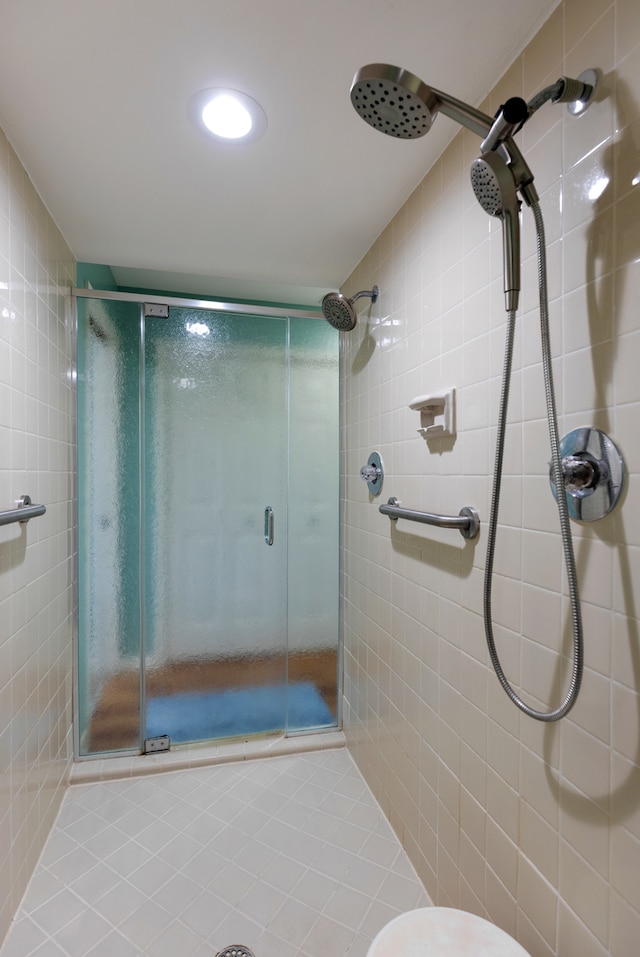 bathroom featuring toilet, tile walls, and walk in shower