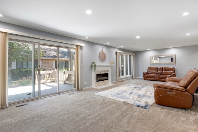 living room with a high end fireplace and carpet flooring