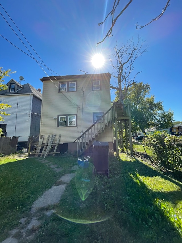 rear view of property featuring a lawn