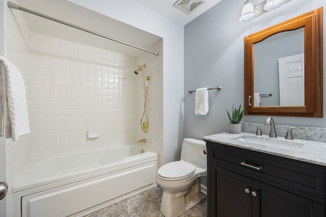 full bathroom featuring tiled shower / bath, vanity, and toilet