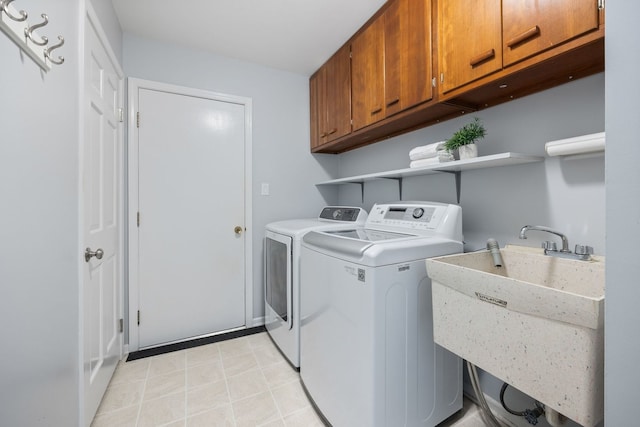 washroom featuring cabinets, sink, and washing machine and clothes dryer