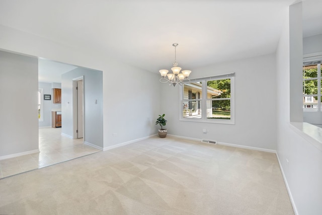 unfurnished room with a wealth of natural light, a chandelier, and light colored carpet