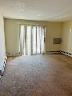 carpeted empty room featuring a baseboard radiator