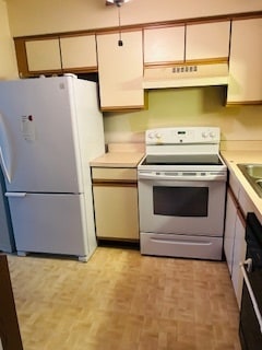 kitchen with white appliances and light parquet flooring