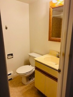 bathroom with toilet, baseboard heating, and vanity