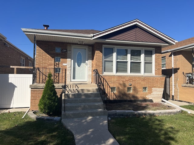 bungalow-style house with brick siding and fence