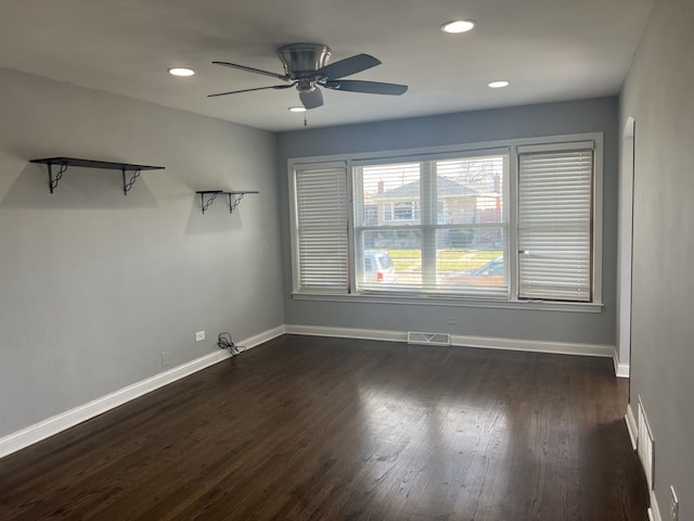 empty room with ceiling fan and dark hardwood / wood-style flooring