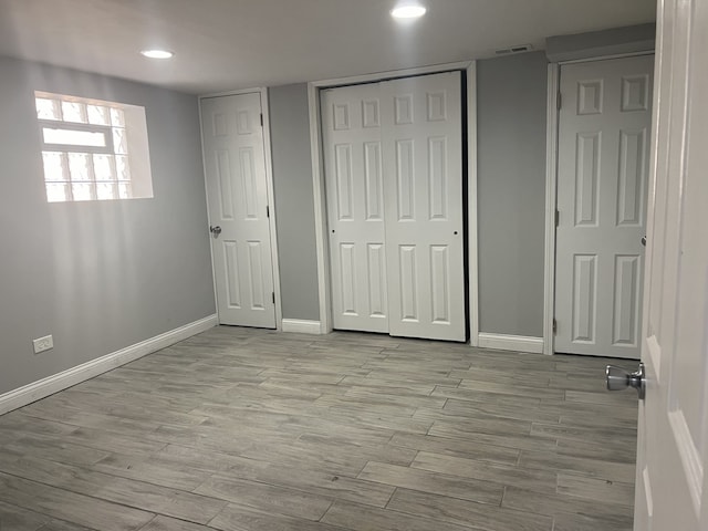 unfurnished bedroom featuring two closets and light wood-type flooring